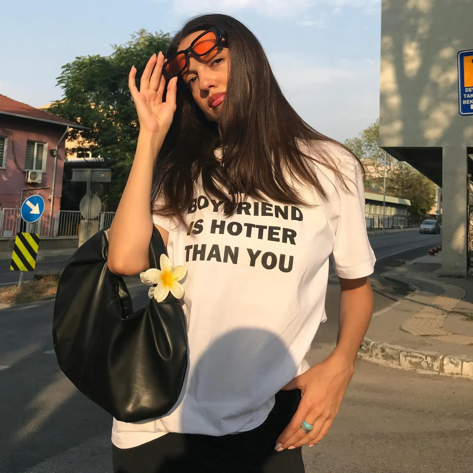 Model wearing a stylish My Boyfriend Is Hotter Than You T-shirt, exuding confidence on the street.